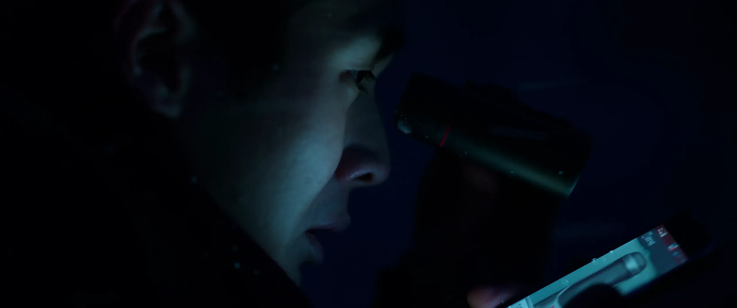 Ki-woo watching through a monocular and recording the house’s blinking lights on his phone.