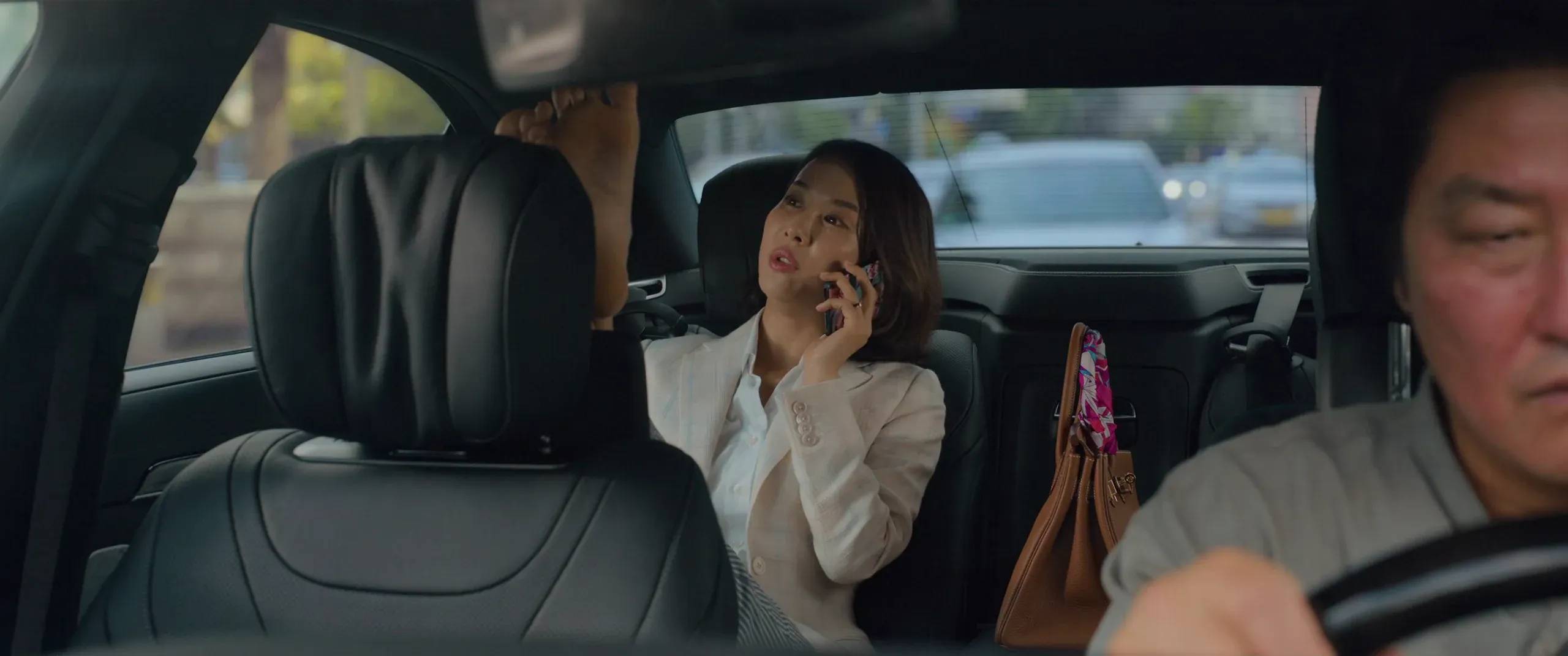 Mrs. Park on the phone in the back seat the morning after the flood, Ki-taek at the wheel