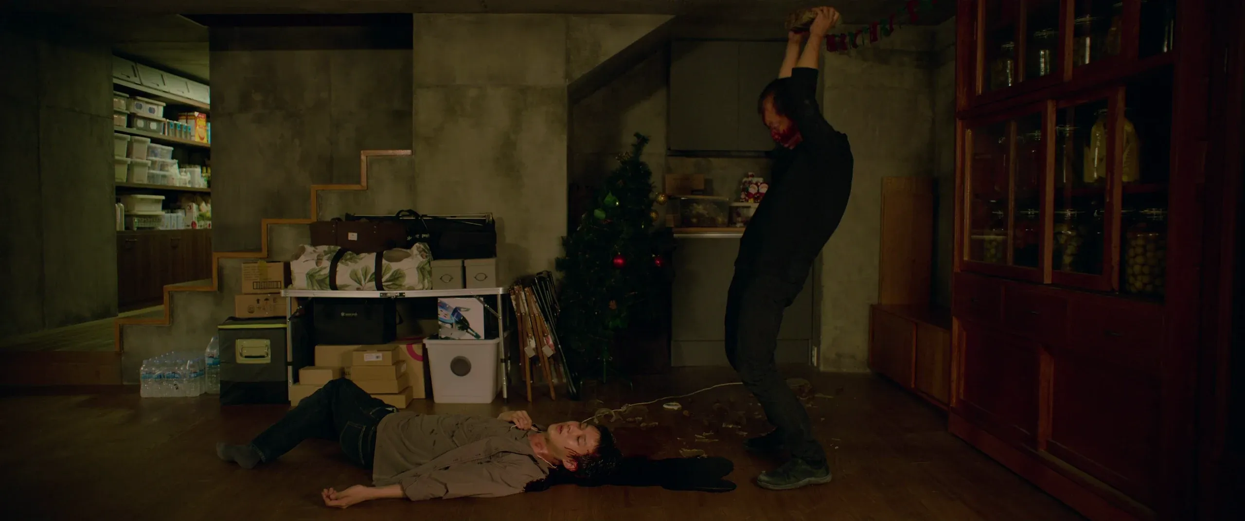 Geun-sae raising the rock over Ki-woo in the basement